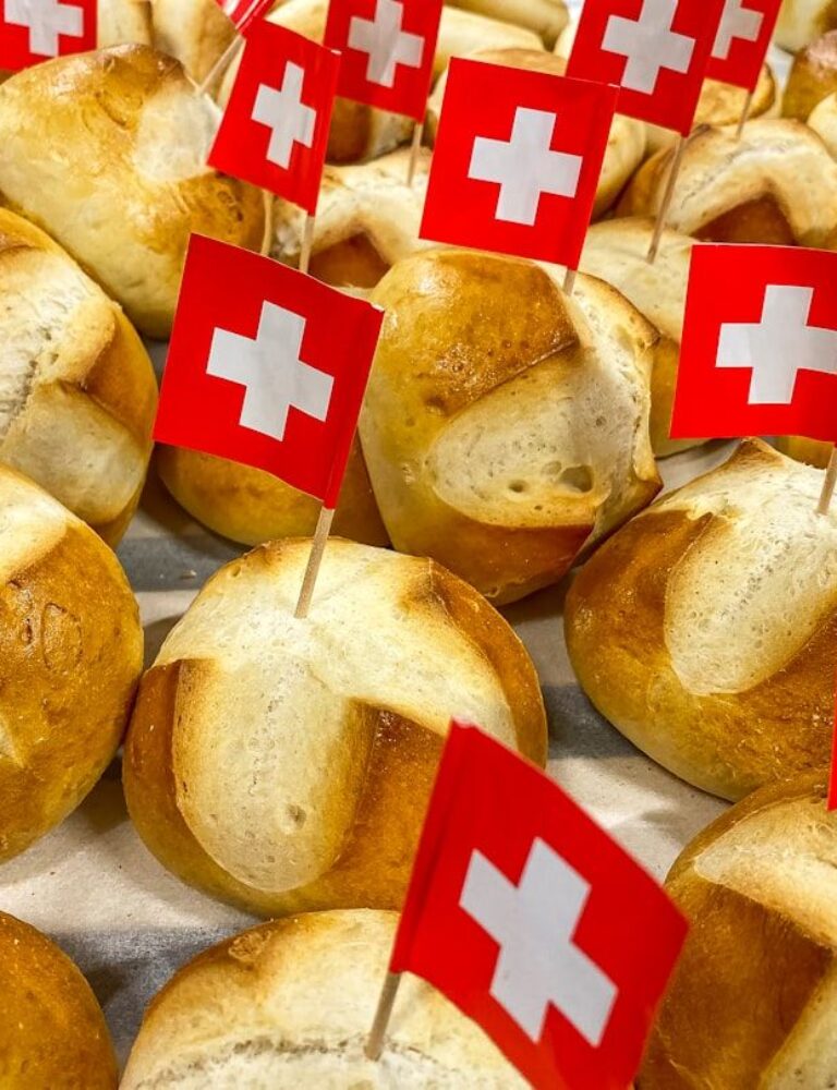 Traditional Swiss bread rolls decorated with small Swiss flags.
